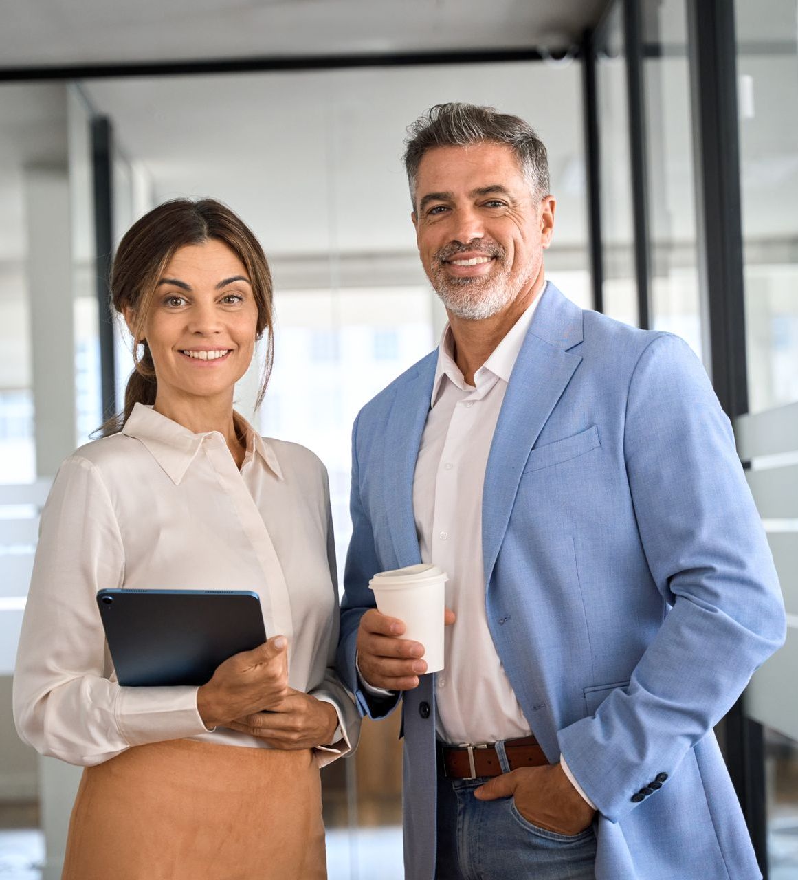 A man and a woman are standing next to each other in an office.