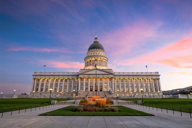 The capitol building in salt lake city is lit up at sunset.