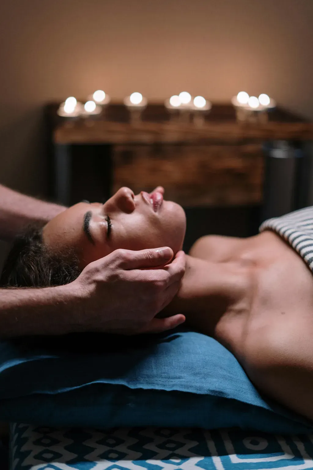 Un homme fait un massage de la tête à une femme dans un spa.