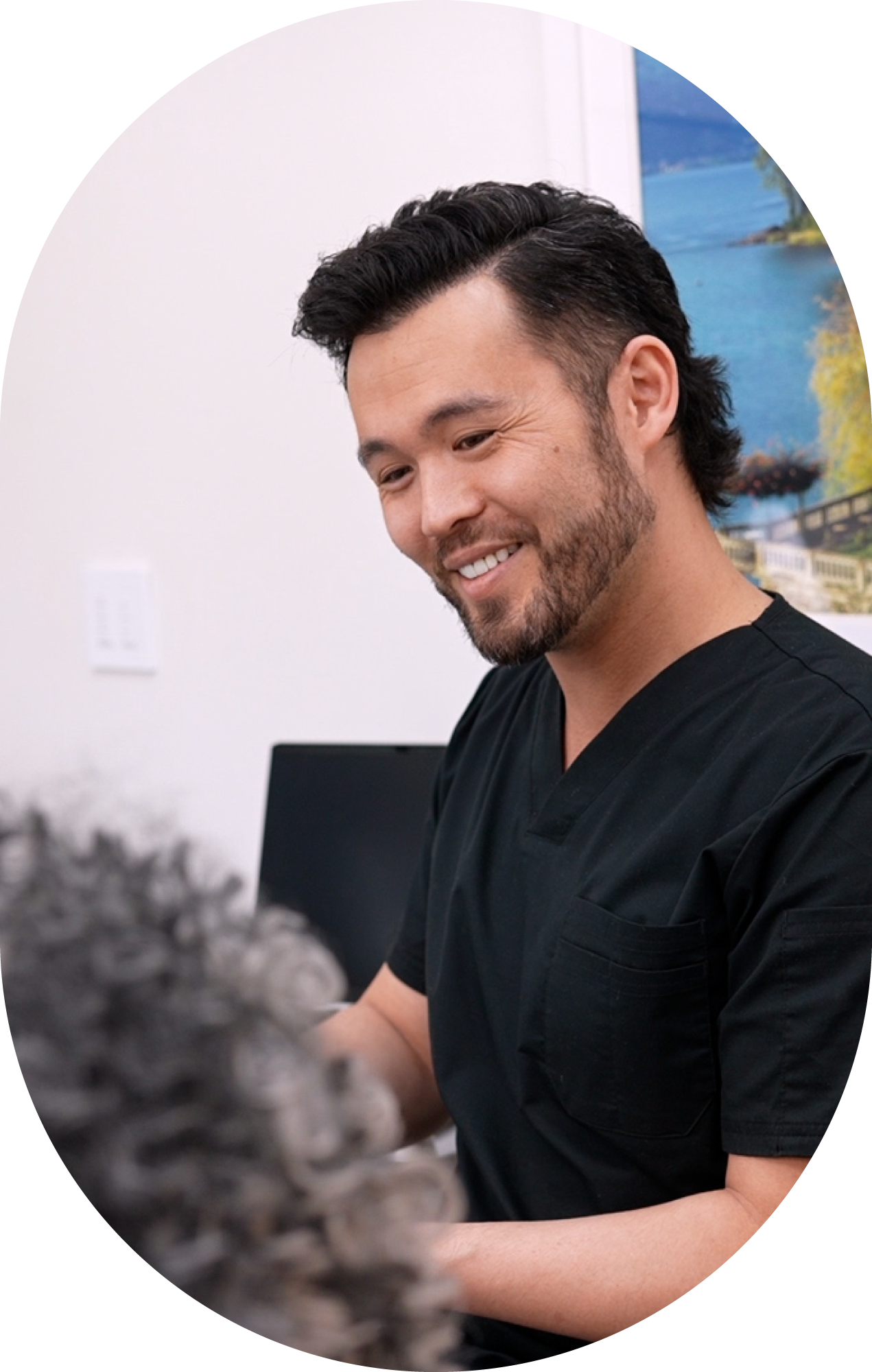 A man in a black scrub top talking to a patient