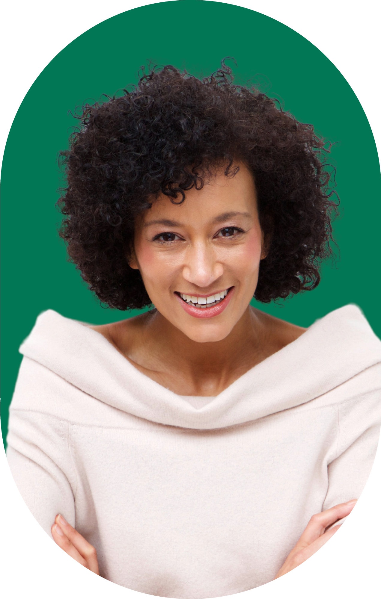 A woman with curly hair is smiling in front of a green background