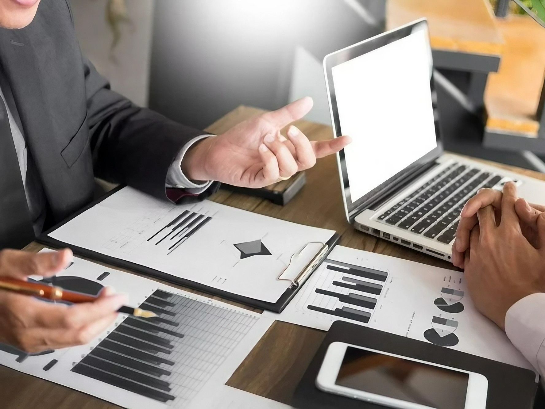 Two Men Are Sitting at A Table Looking at A Laptop Computer — Early Bird Accounts in Tamworth, NSW