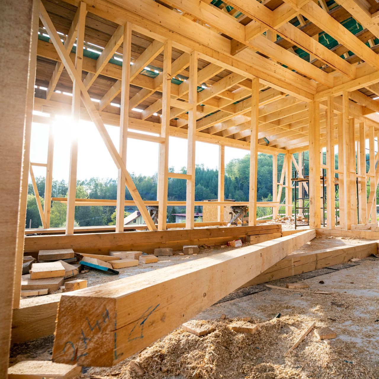Le soleil brille à travers le toit d'une structure en bois en construction.