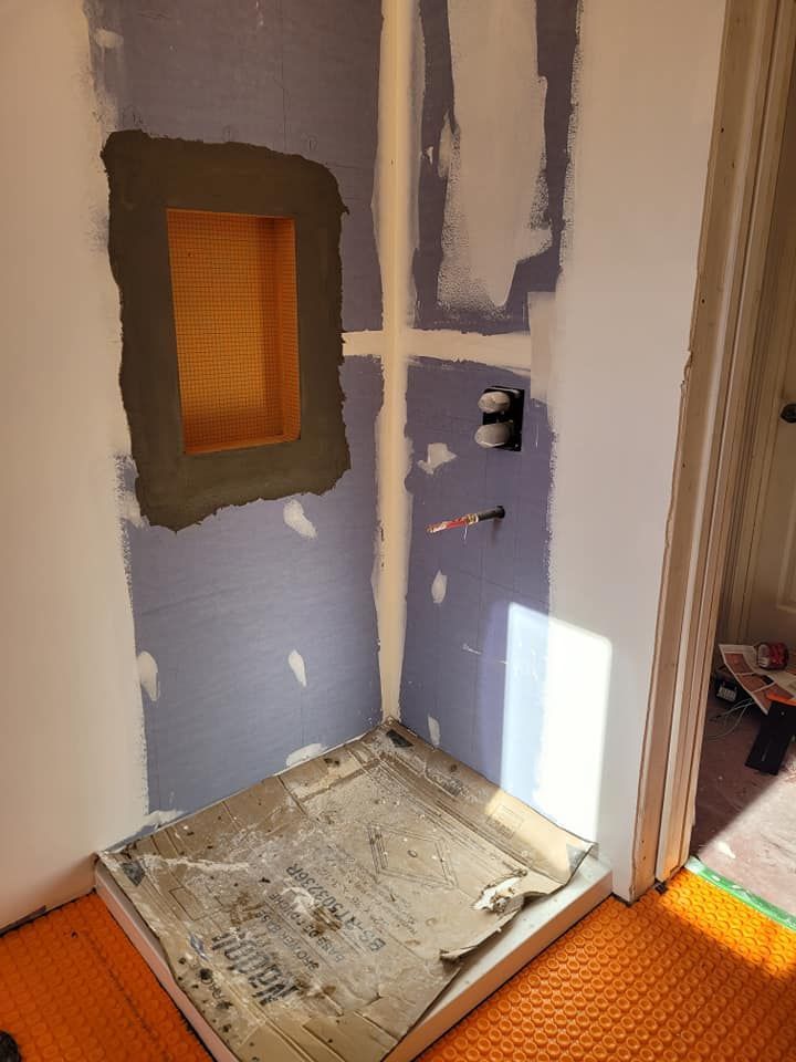 Une cabine de douche est en cours de construction dans une salle de bain.