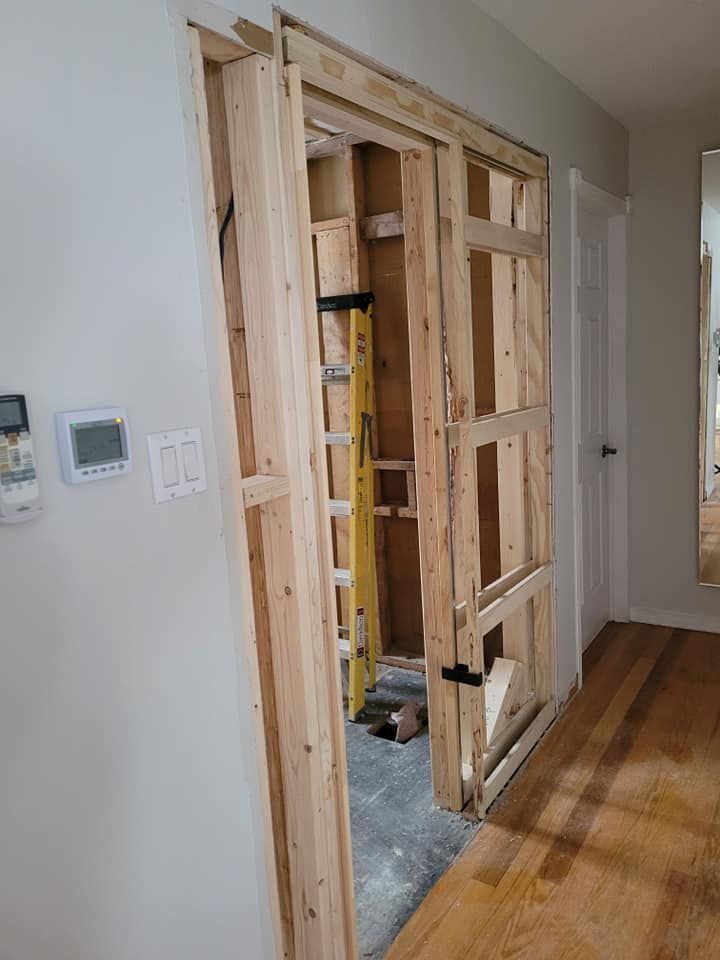 Une porte en bois est en train d'être construite dans un mur dans un couloir.