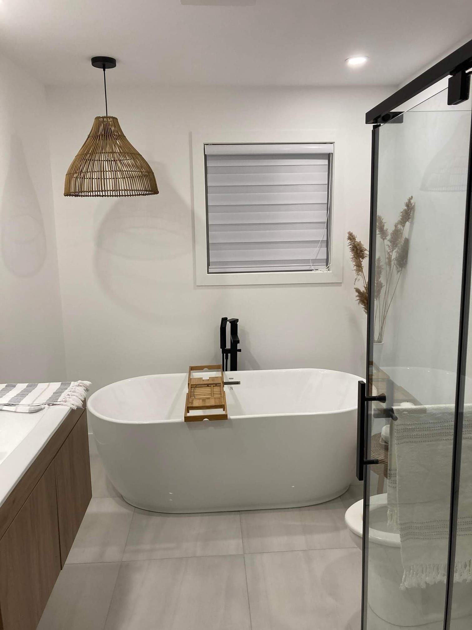 Une salle de bain avec baignoire, WC, douche et fenêtre.