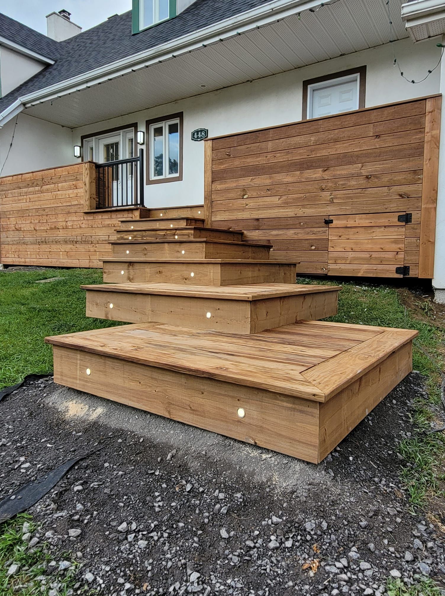 Une terrasse en bois avec des escaliers menant à une maison.