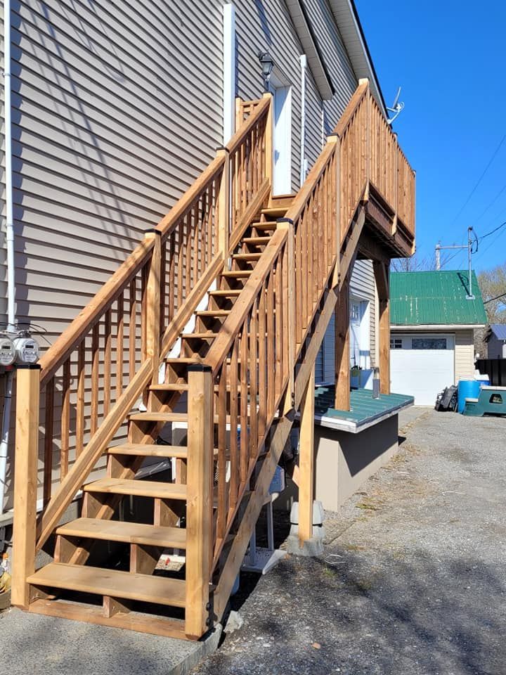 Une terrasse en bois avec des escaliers qui y mènent