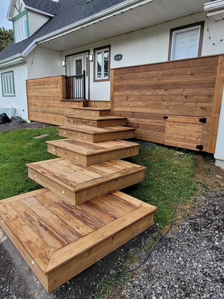 Un escalier en bois se trouve devant une maison.