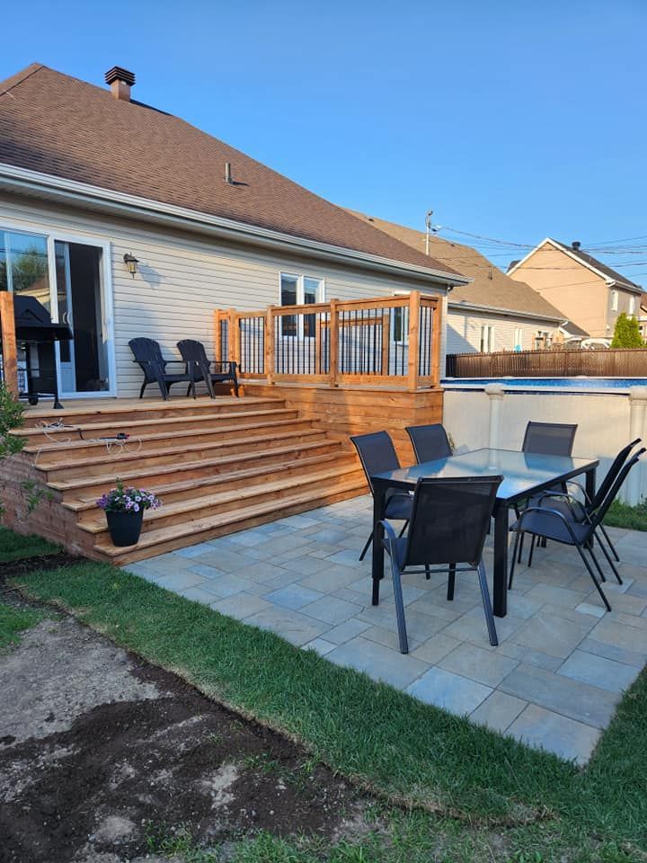 Un patio avec une table et des chaises devant une maison.