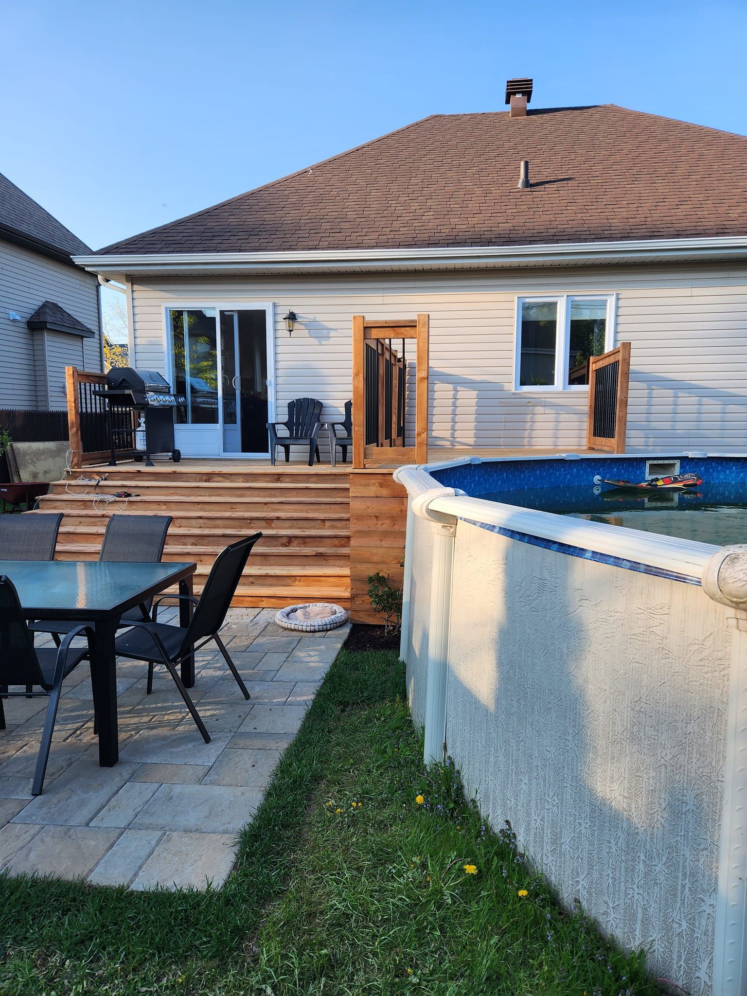 L'arrière-cour d'une maison avec une piscine et une table et des chaises.