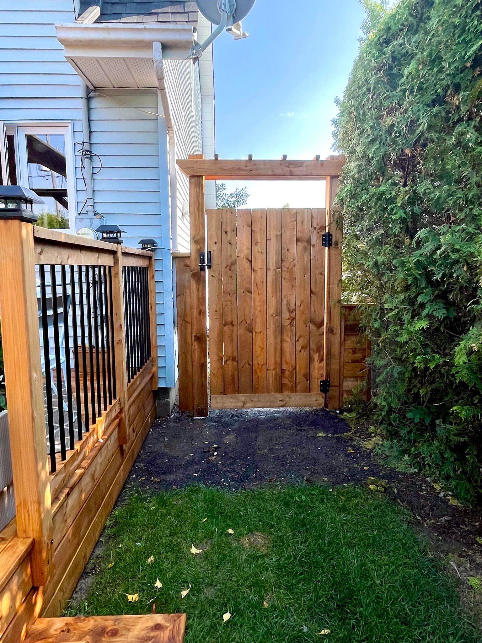 Il y a un portail en bois dans l'arrière-cour d'une maison.