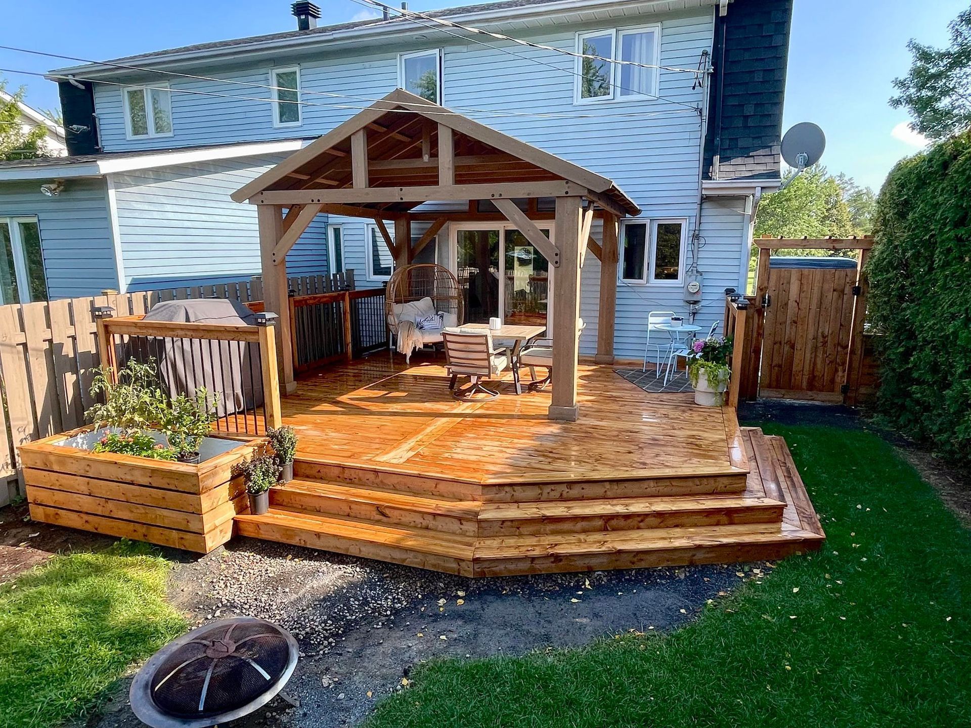 Une terrasse en bois avec un gazebo dans l'arrière-cour d'une maison.
