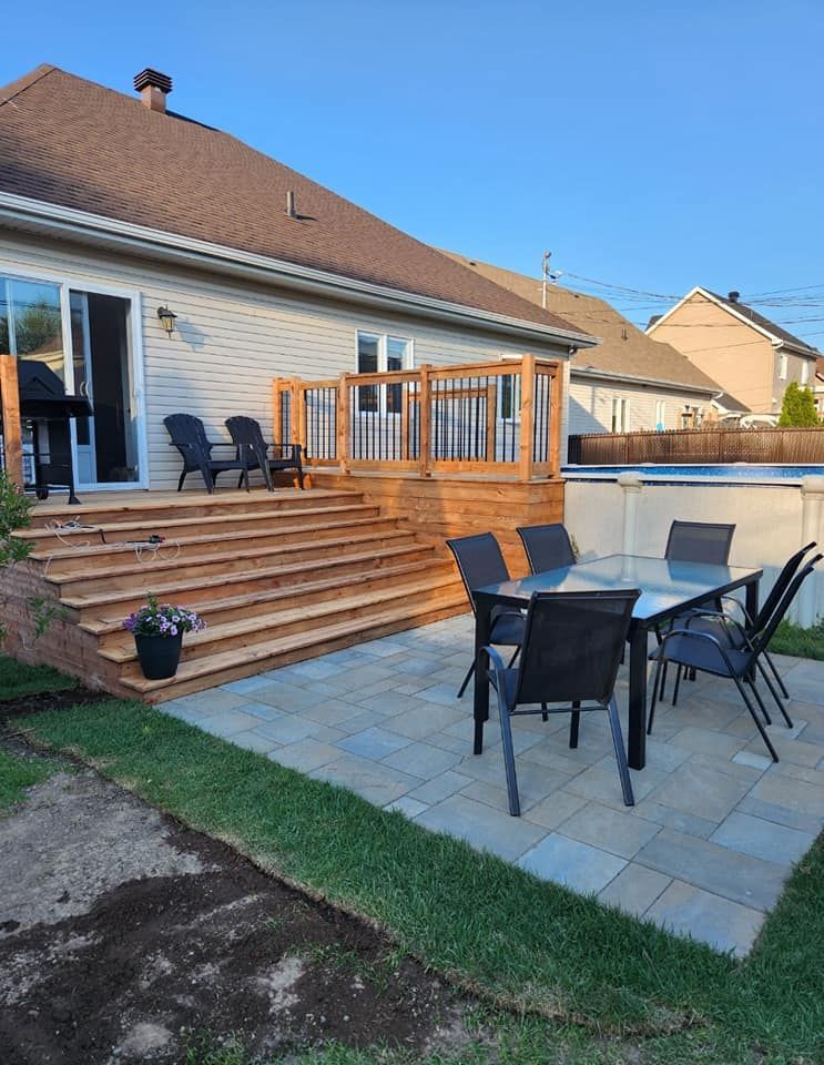 Il y a une table et des chaises sur le patio devant une maison.
