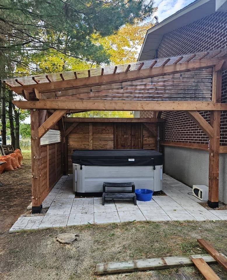 Un bain à remous est installé sous une pergola en bois.
