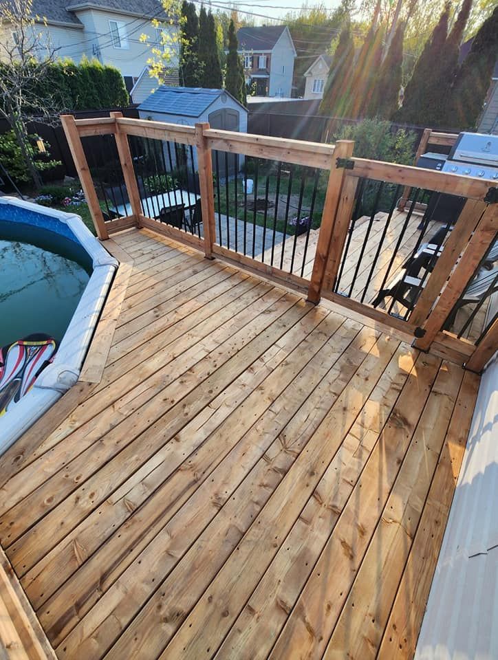 Une terrasse en bois avec une piscine en arrière-plan.