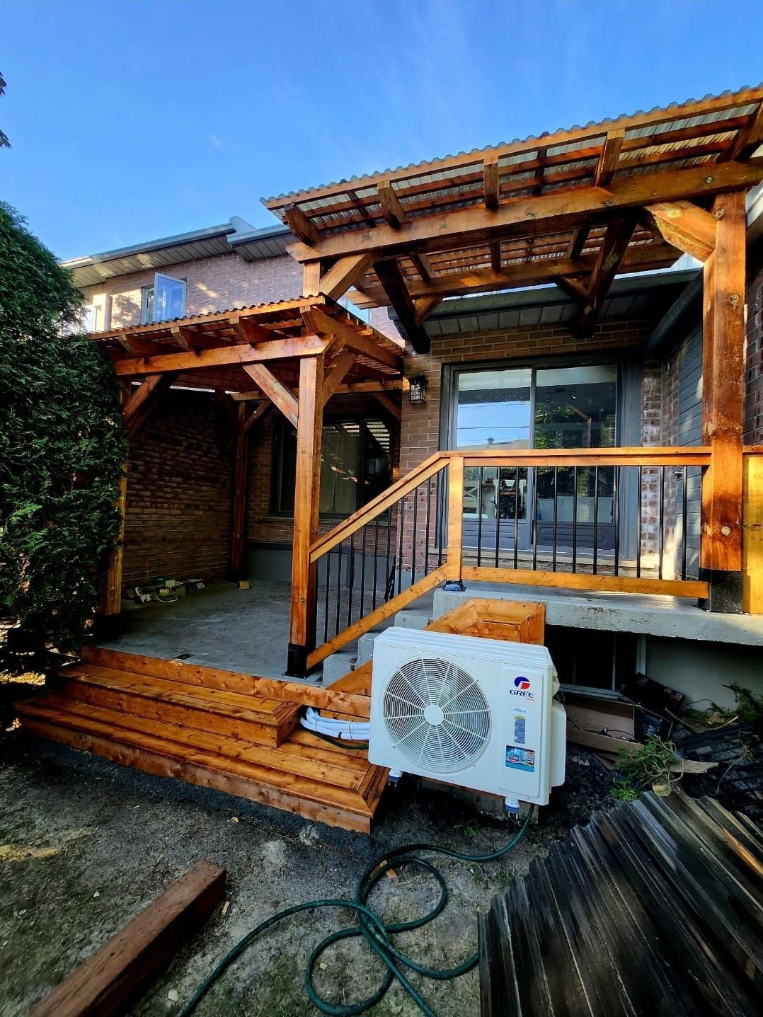 Une terrasse en bois avec des escaliers et un ventilateur dessus.