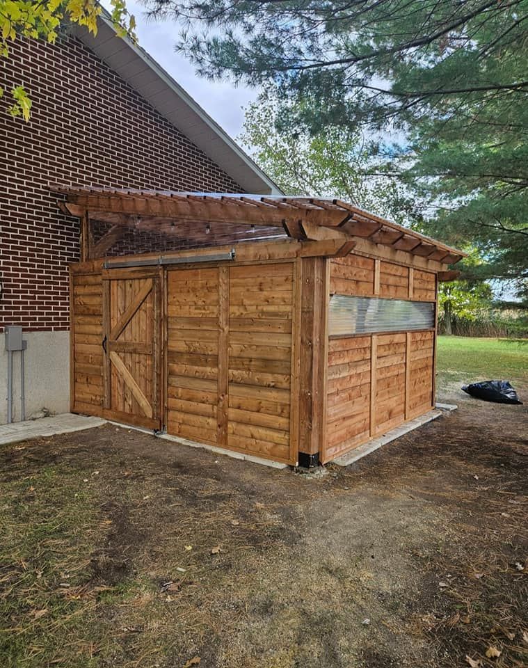 Un hangar en bois se trouve devant un bâtiment en briques.