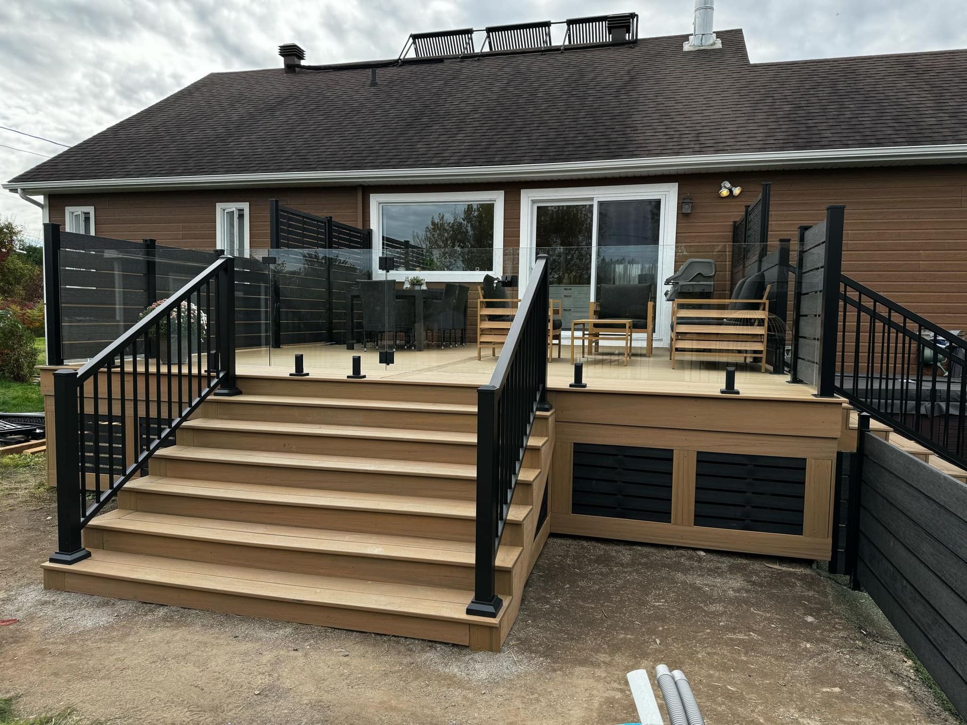 Une maison avec une terrasse et des escaliers devant.