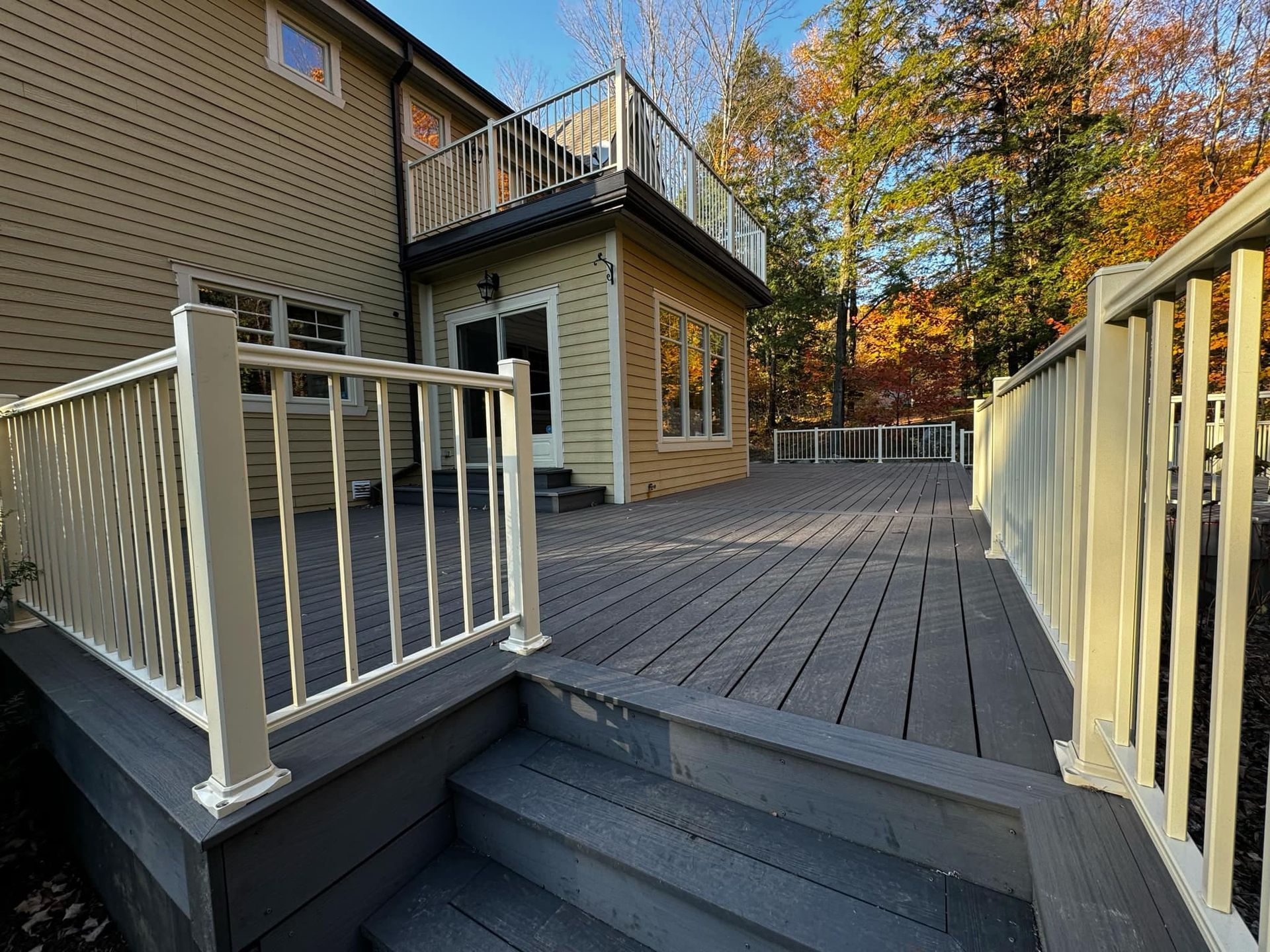 Une terrasse avec des escaliers qui y mènent et une maison en arrière-plan.