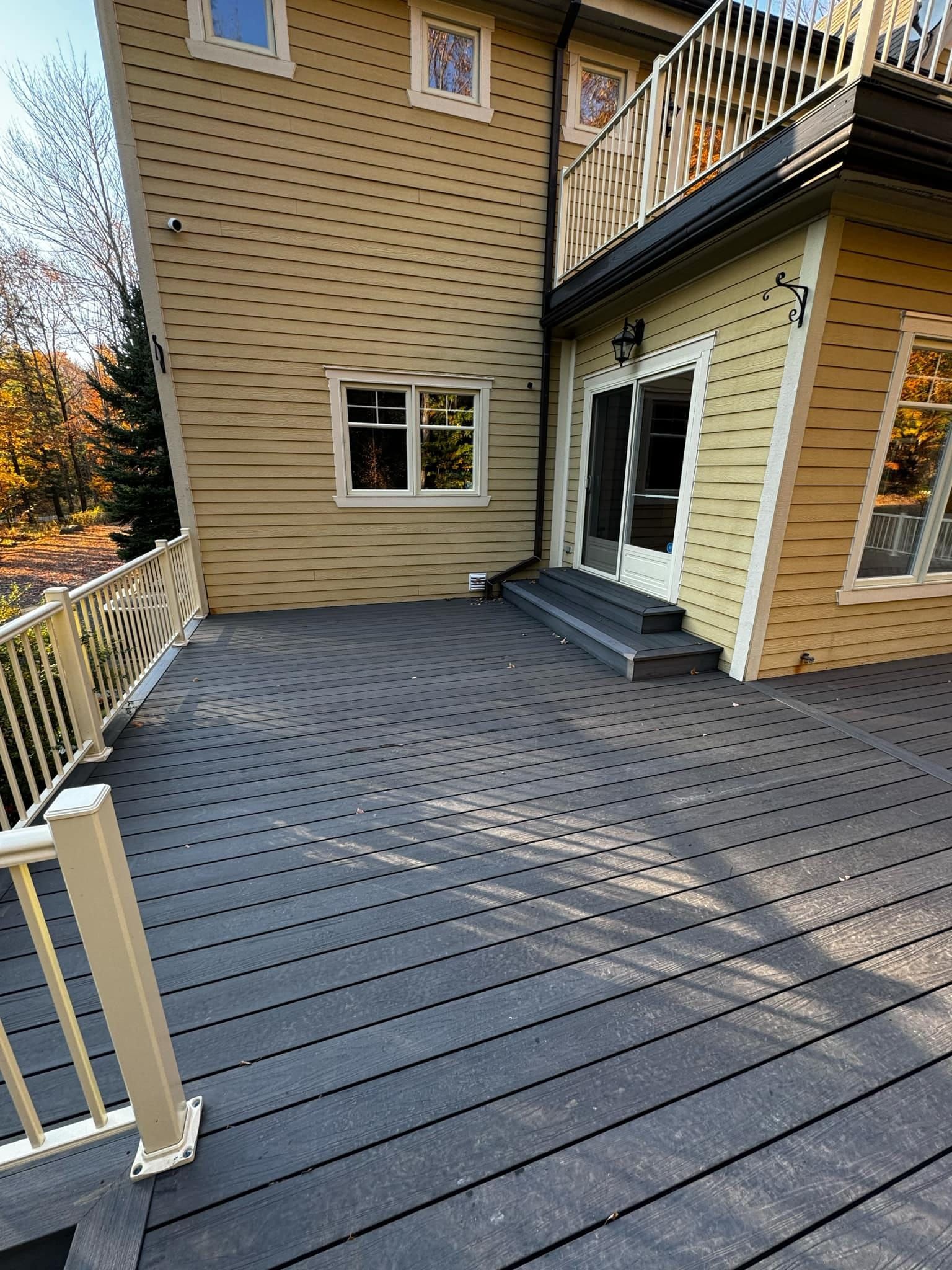 Il y a une grande terrasse devant une maison.