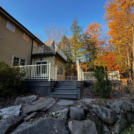 Une maison avec une grande terrasse et des escaliers qui y mènent
