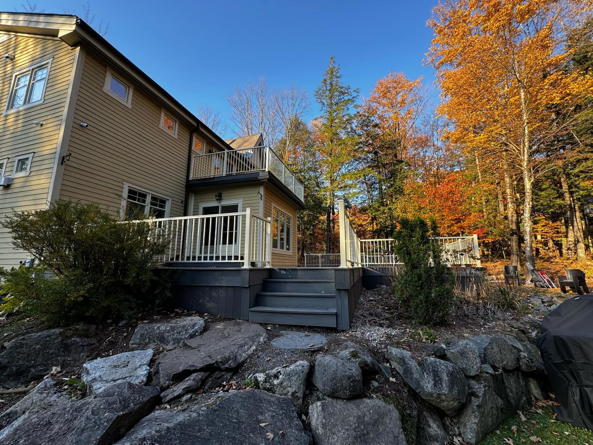 Une grande maison avec une grande terrasse et des escaliers devant.