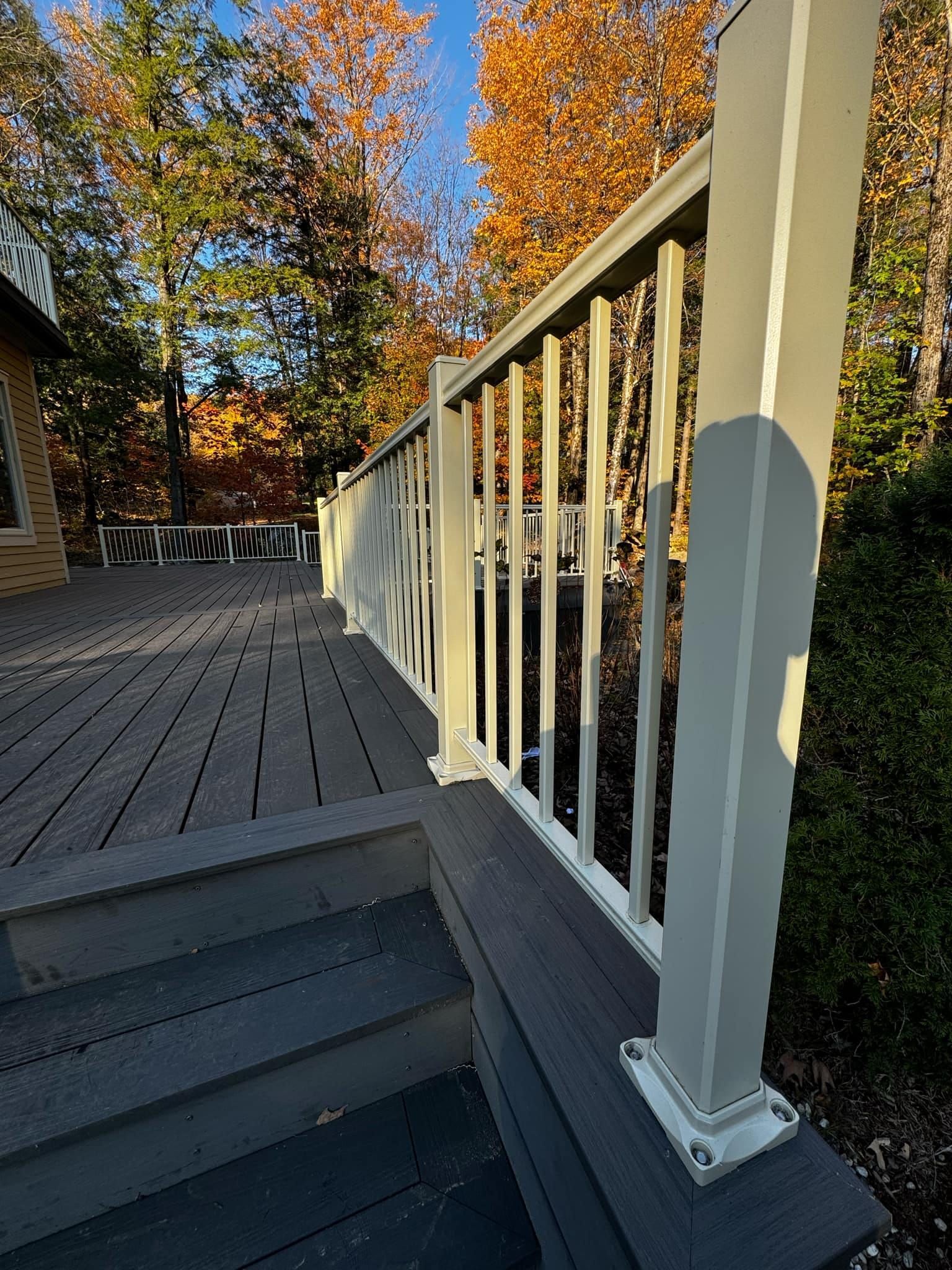 Une balustrade blanche sur une terrasse avec des escaliers qui y mènent.