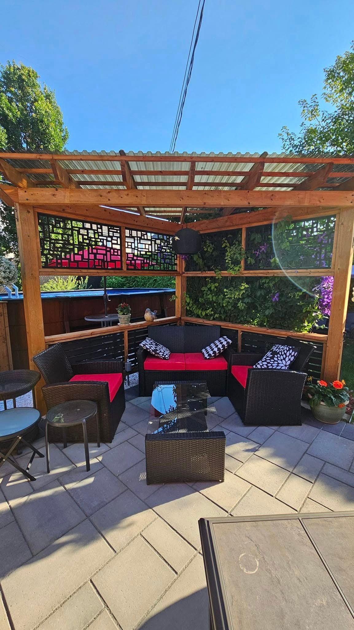 Un patio avec une pergola et un canapé et des chaises.