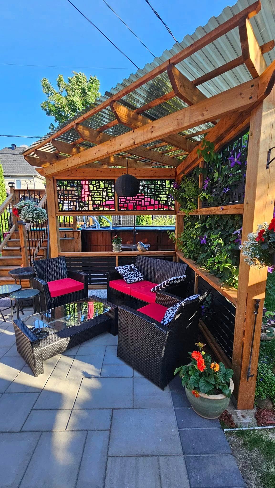 Une pergola en bois avec un canapé et des chaises en dessous dans une cour arrière.
