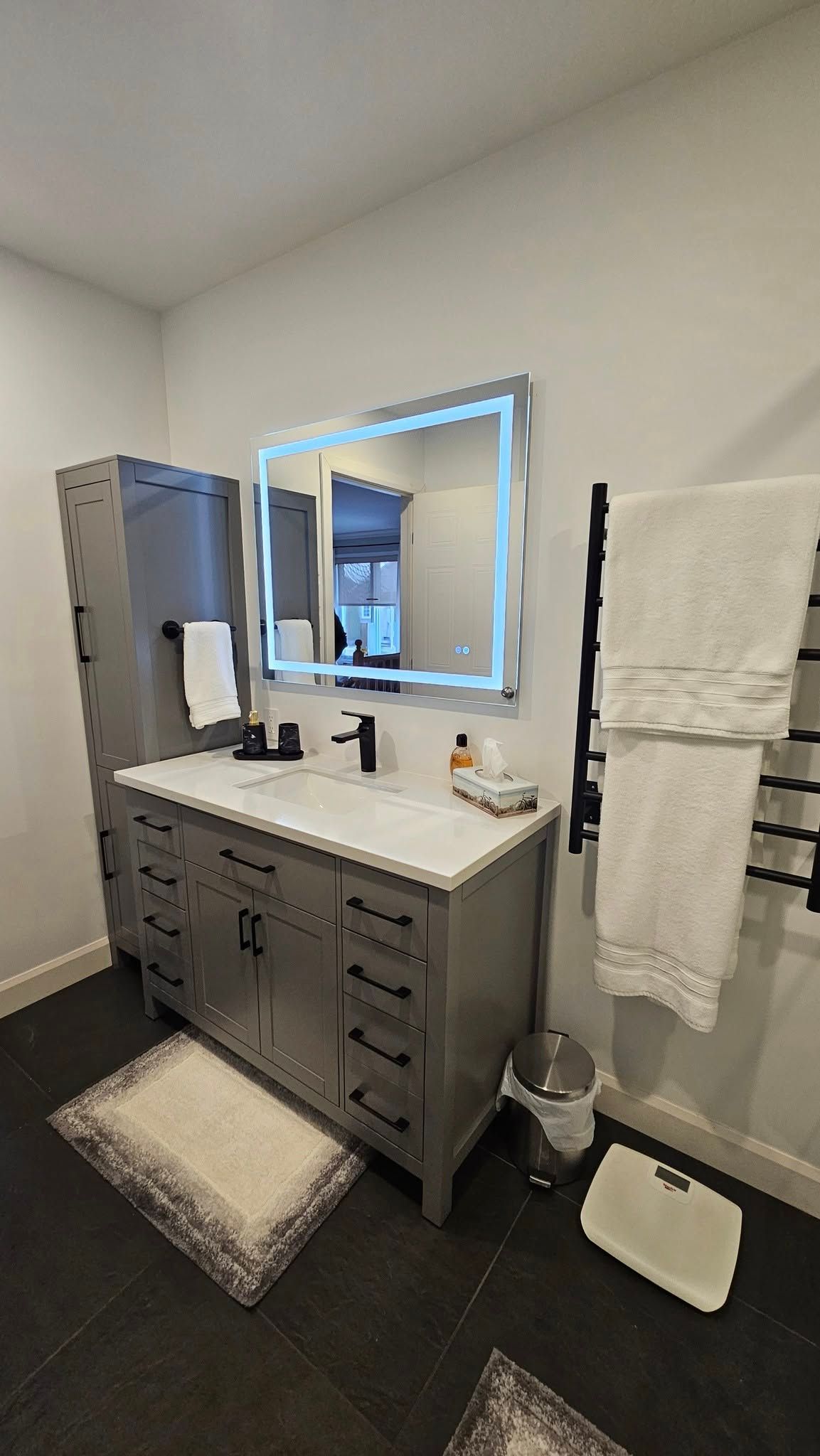 Une salle de bain avec un lavabo, un miroir et des serviettes.