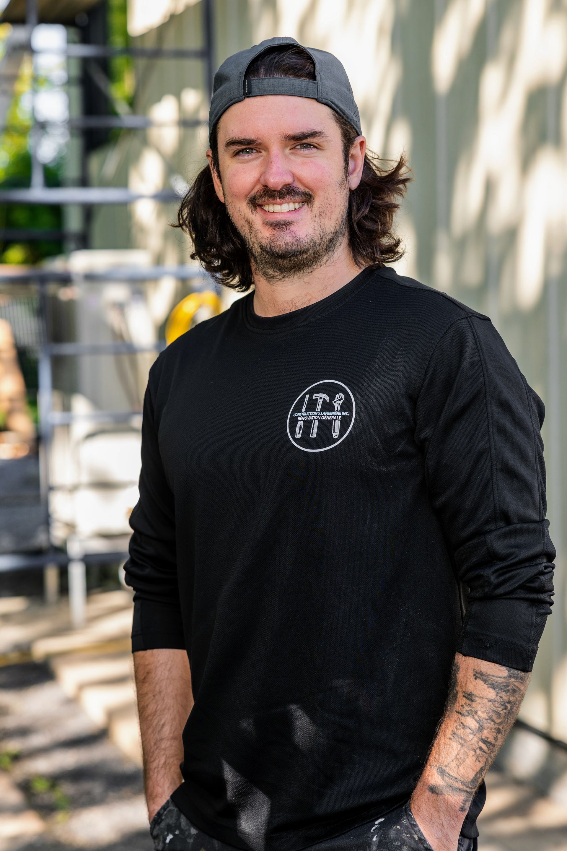 Une femme aux cheveux blonds sourit et porte une chemise noire.