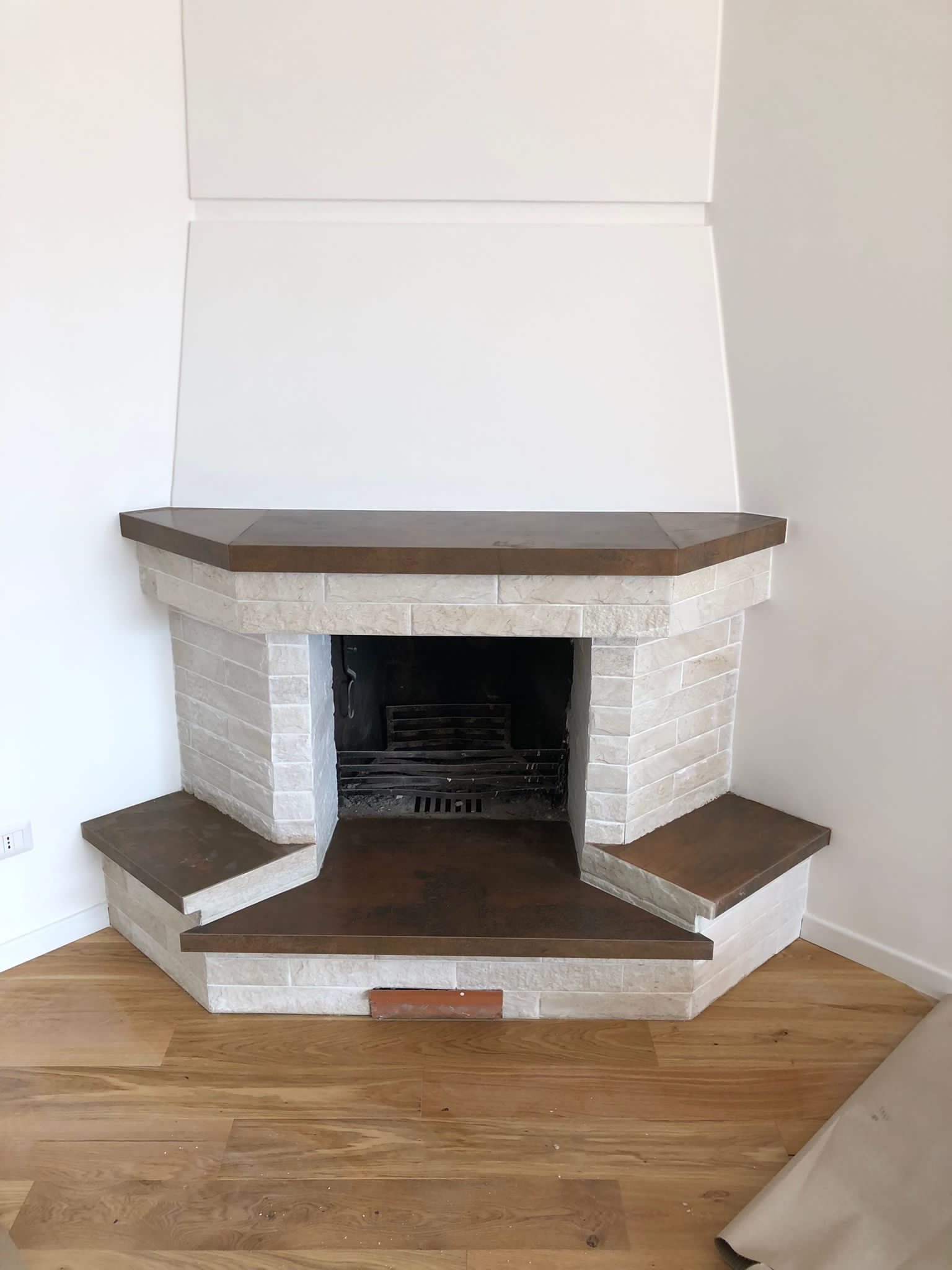 Un camino in un angolo di una stanza con pavimenti in legno