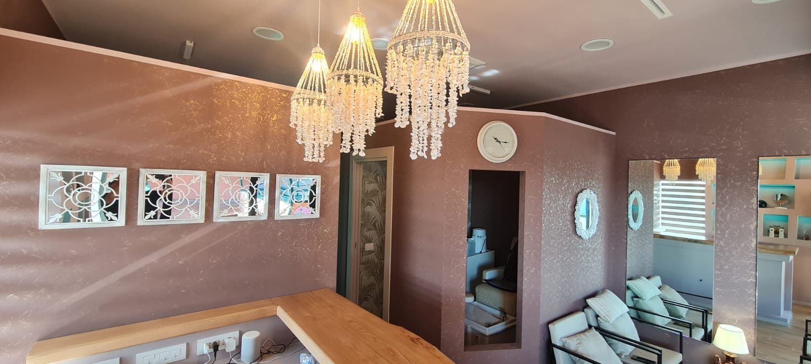 Una stanza con un orologio sul muro e un lampadario appeso al soffitto.