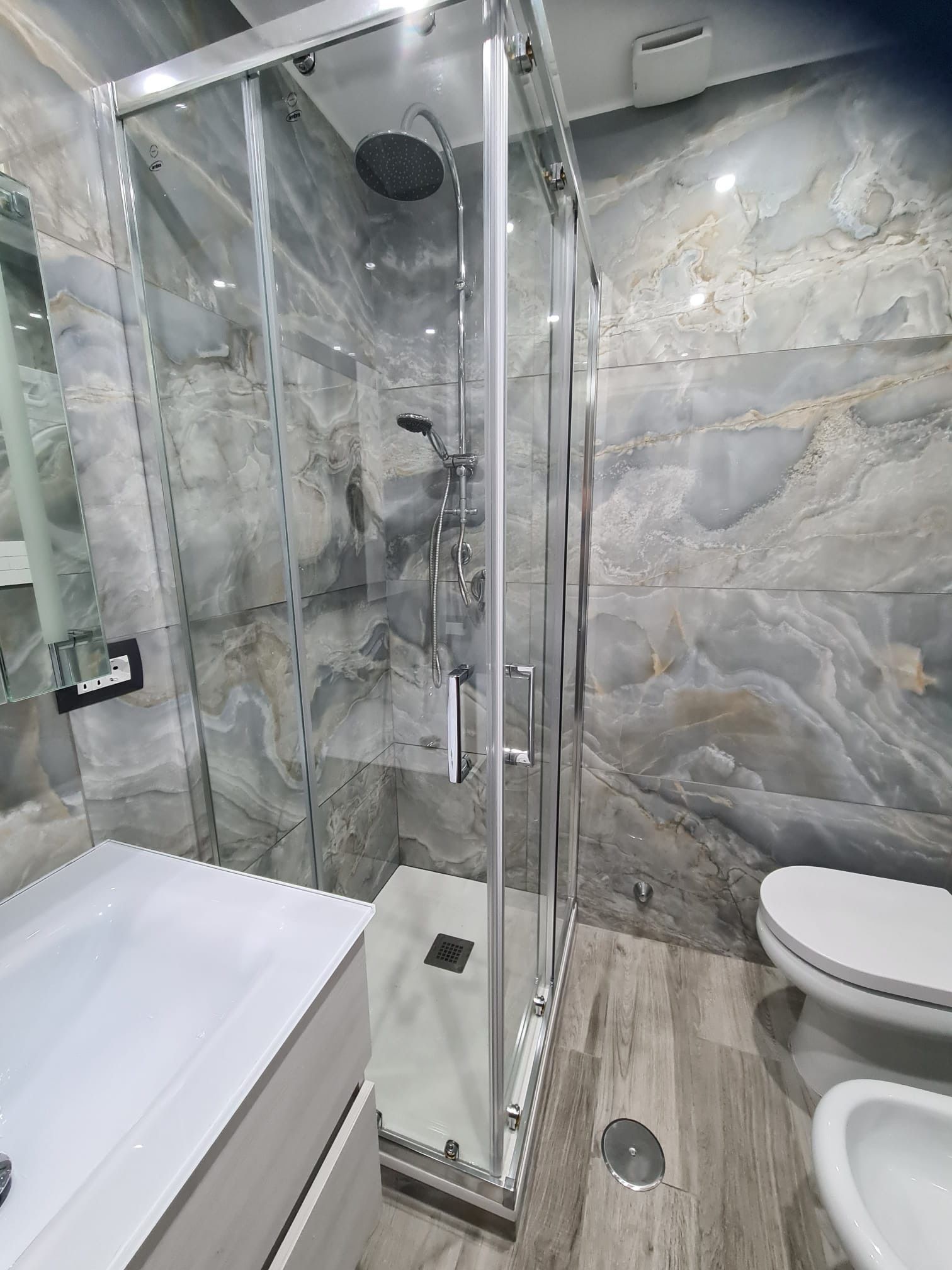 Un bagno con doccia, wc e lavandino.