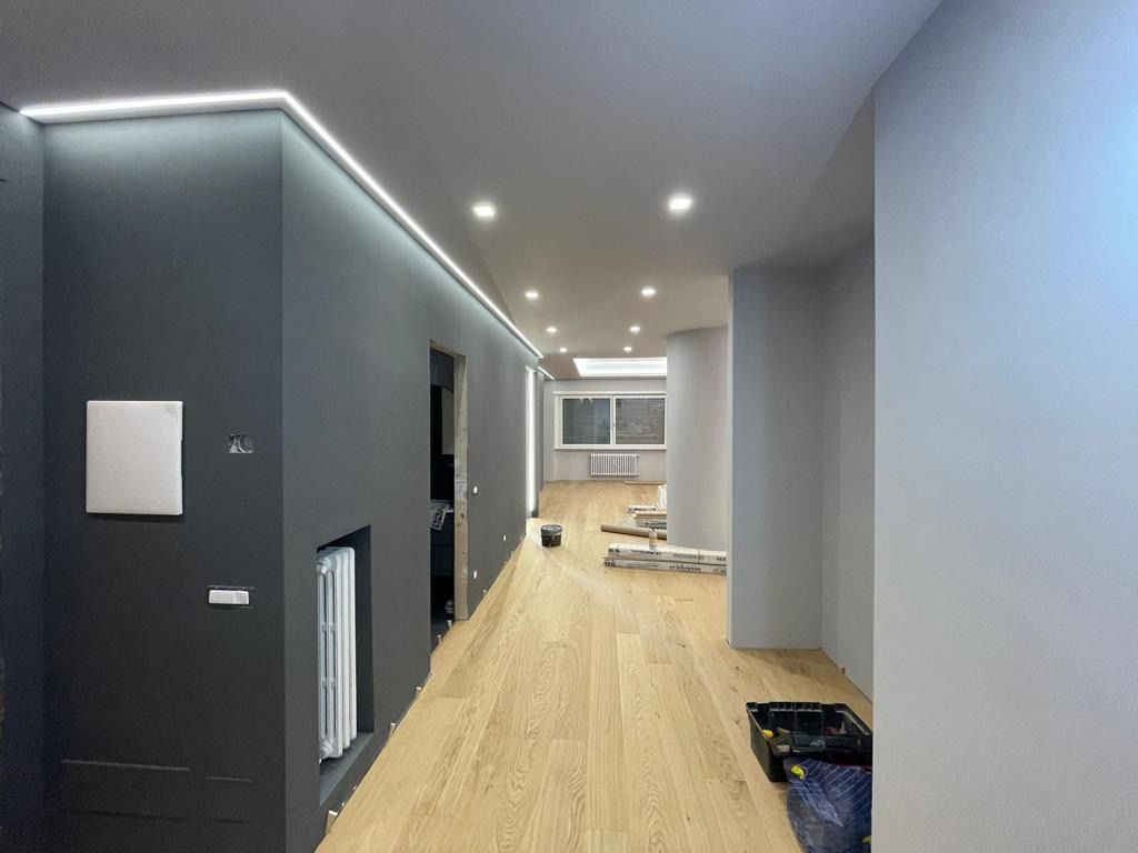 Un corridoio con pavimento in legno e parete nera