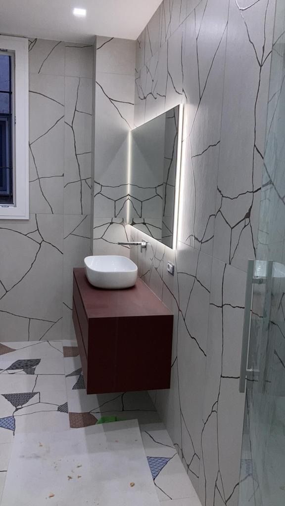 Un bagno con lavandino, specchio e doccia.