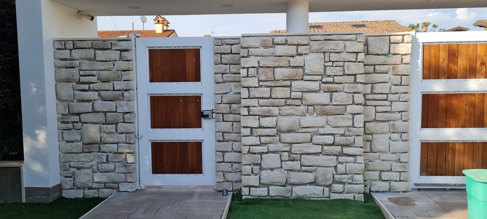 Un muro di pietra con un cancello di legno davanti.