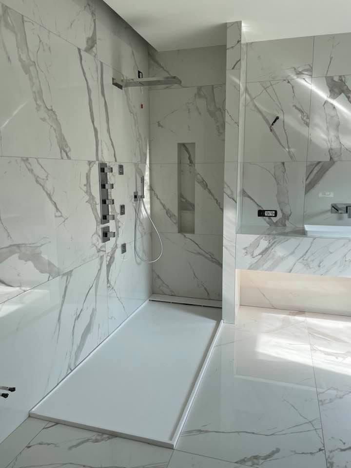 Un bagno con piastrelle in marmo e cabina doccia.