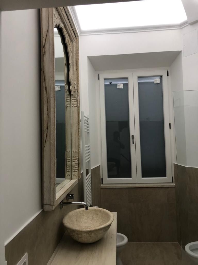 Un bagno con un lavandino uno specchio e una finestra