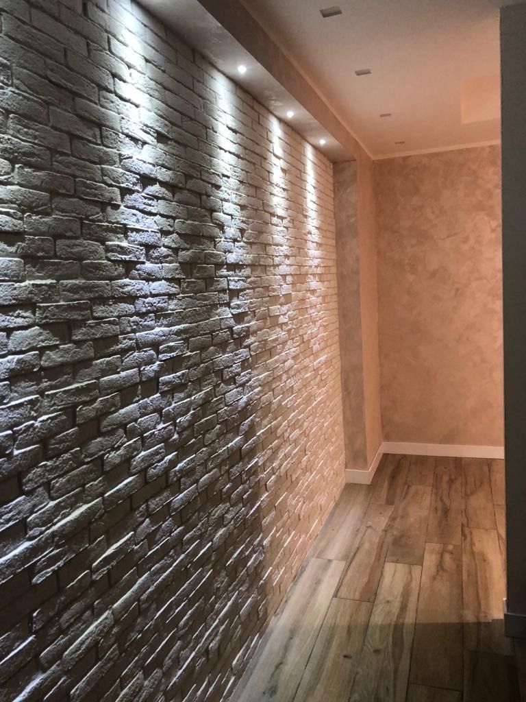 Un corridoio con un muro di mattoni e pavimento in legno