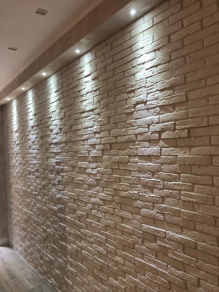 Un muro di mattoni con luci in un corridoio.