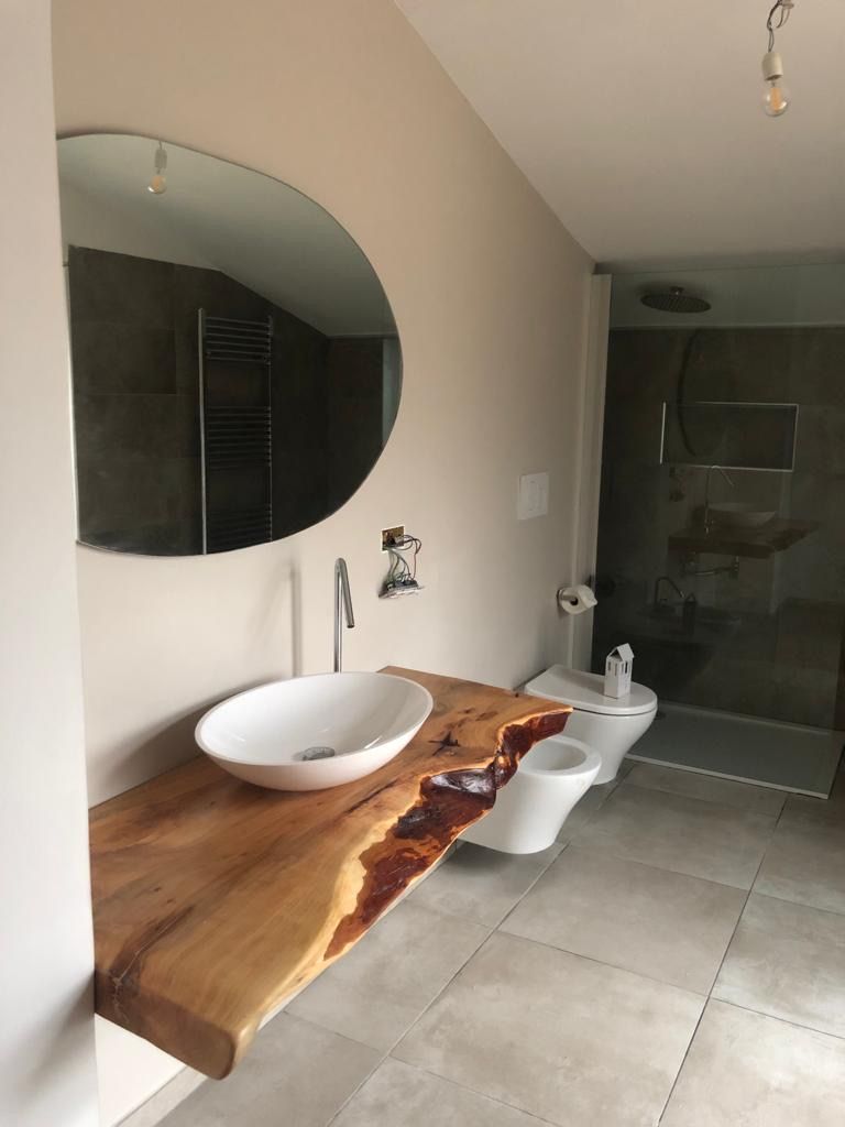 Un bagno con lavandino, water, bidet e specchio.