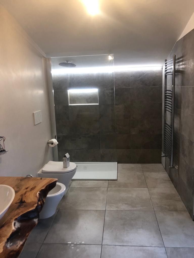 Un bagno con wc, lavandino e cabina doccia.