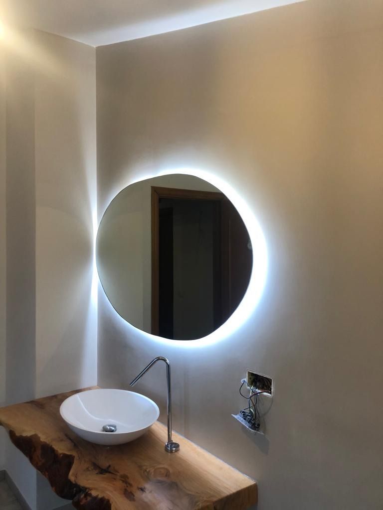 Un bagno con un lavandino e uno specchio rotondo sul muro.