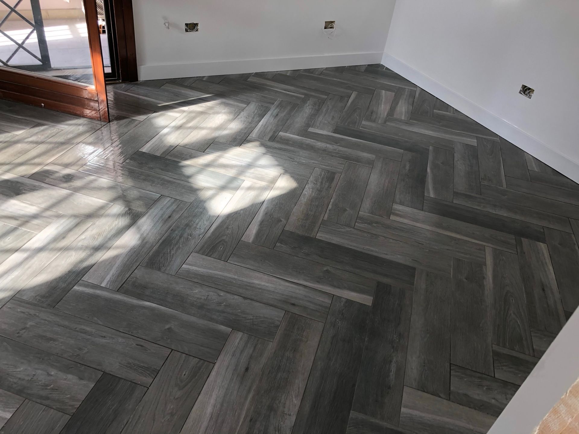 Una stanza con un motivo a spina di pesce sul pavimento.