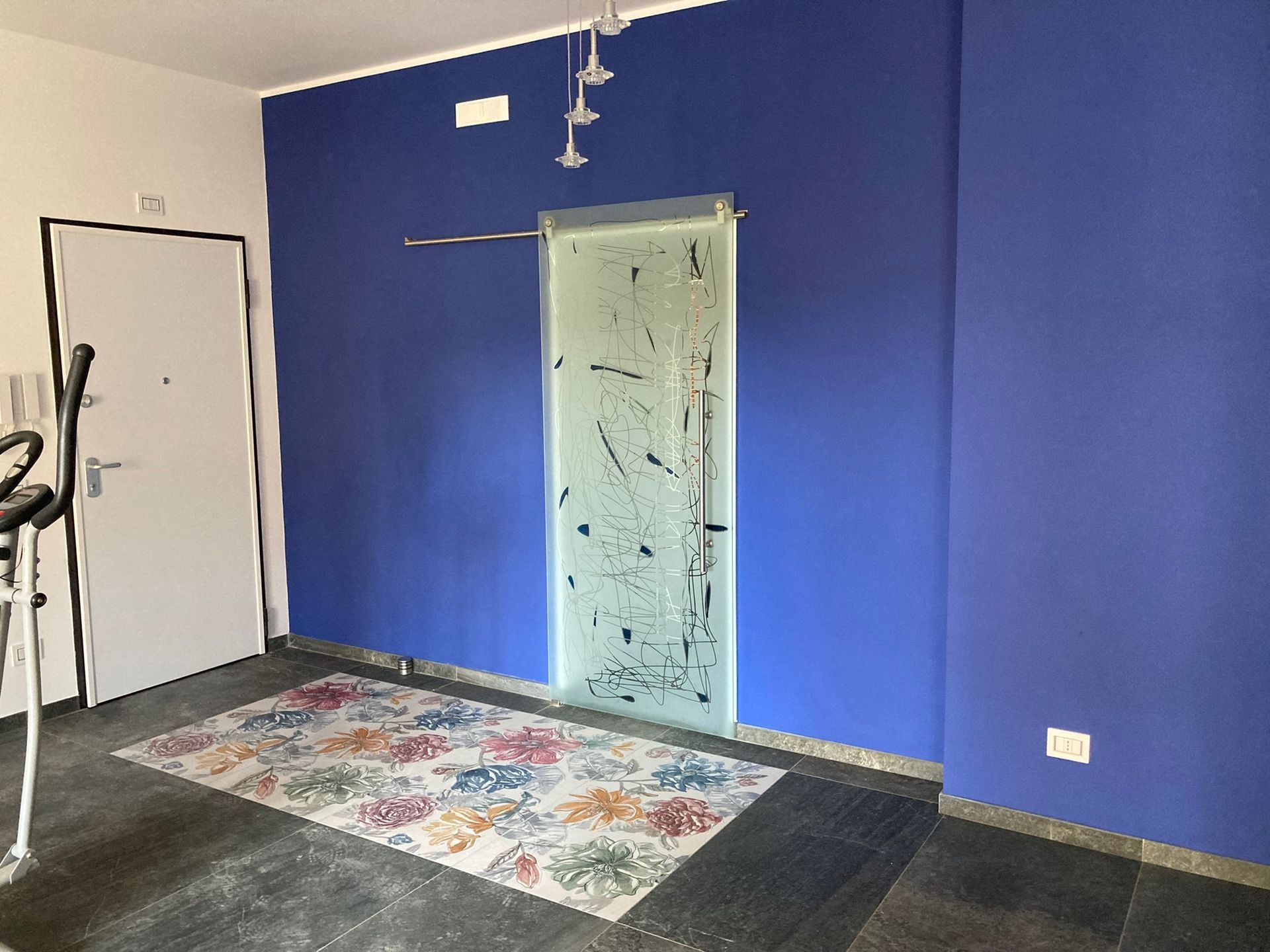 Una stanza con le pareti blu e una porta con un tappeto sul pavimento.