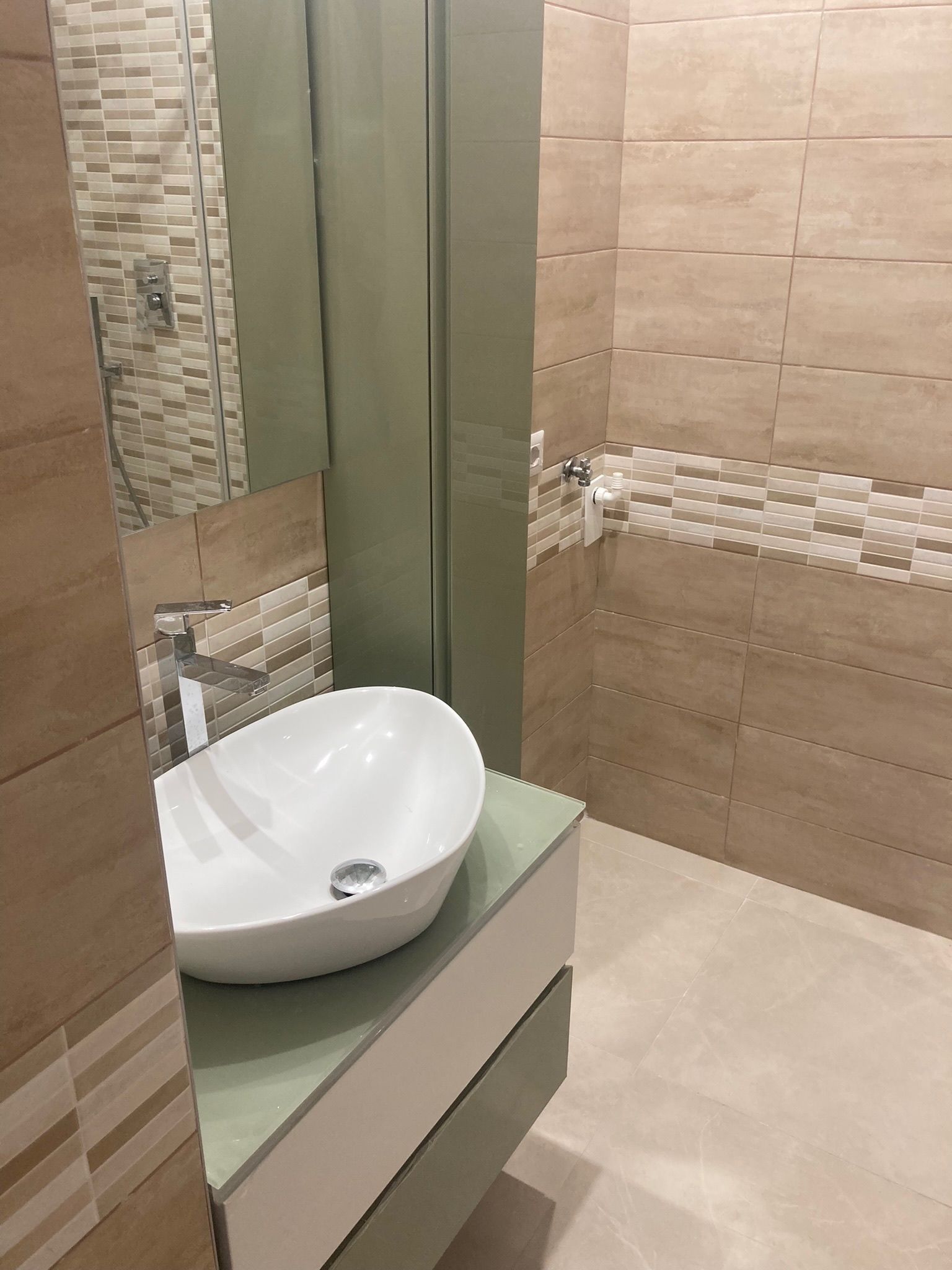 Un bagno con lavandino, specchio e doccia.