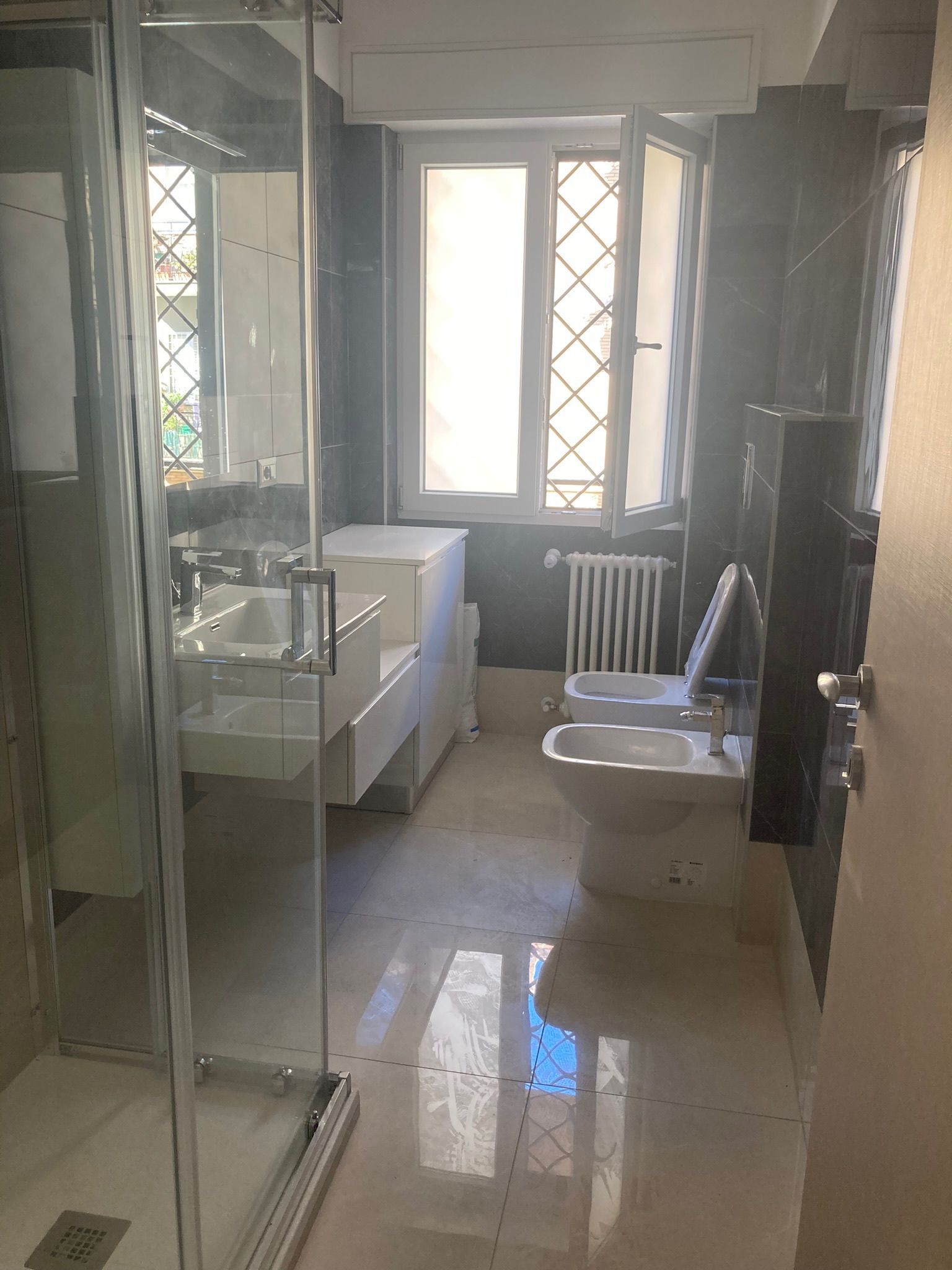 Un bagno con due wc, un lavandino e una doccia.