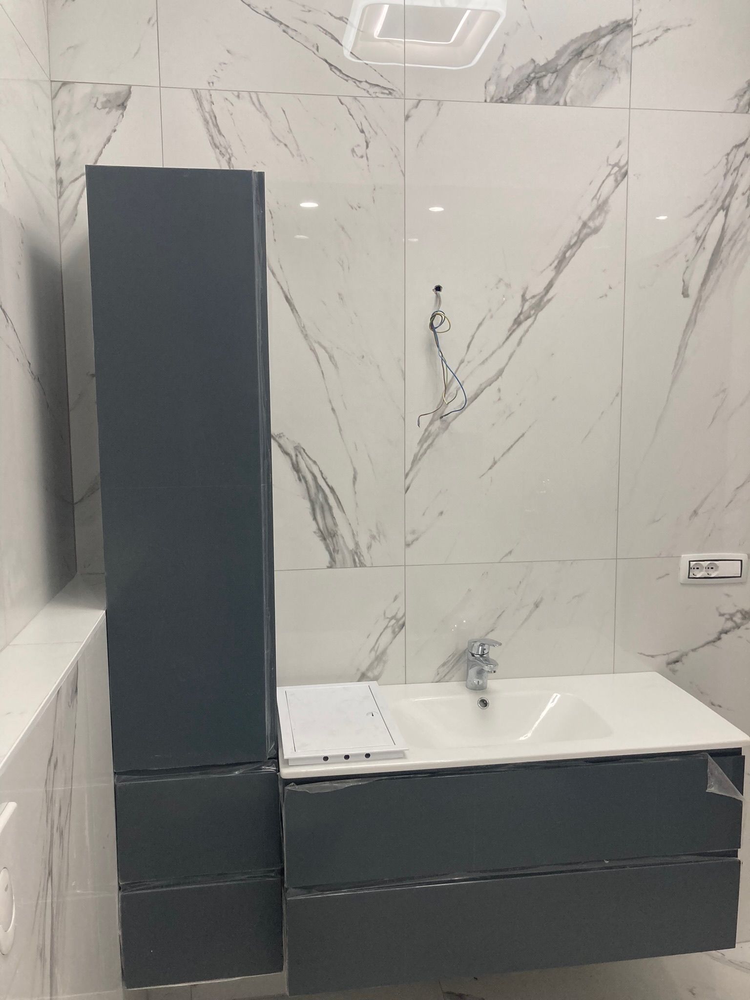 Un bagno con lavandino, armadietti e specchio.